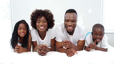 Happy-family-lying-on-bed-in-bedroom