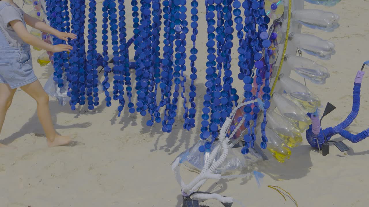 해변 조각과 상호 작용하는 사람