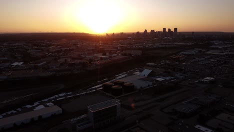 Vista-Aérea-De-La-Hora-Dorada-Del-Centro-De-La-Ciudad-Y-La-Zona-Industrial-De-Calgary