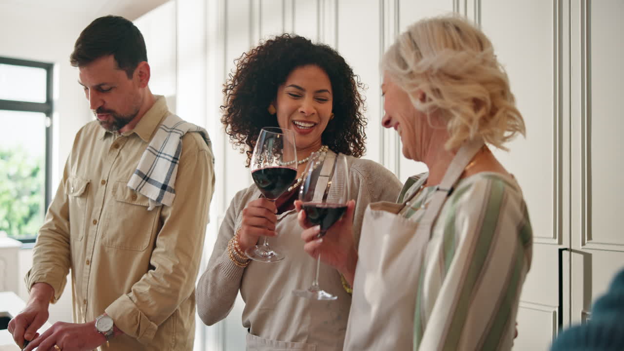 People in the kitchen with wine glasses
