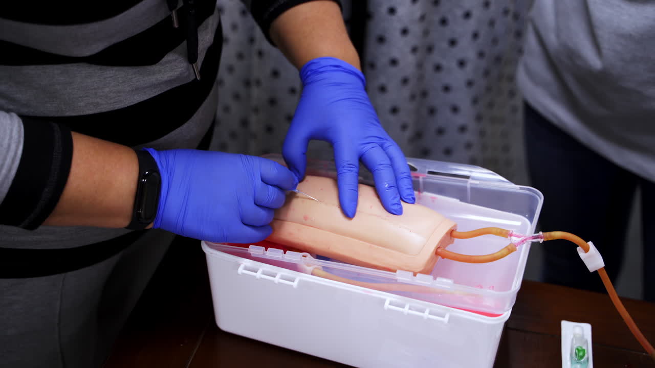 Hands in gloves making injection with a syringe for puncture. Simulation medical training model. Medical procedure concept, simulation medicine training.