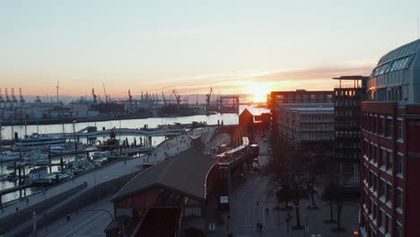 Aerial-dolly-in-view-following-a-train-driving-by-the-river-Elbe-in-Hamburg-city-center-at-sunset