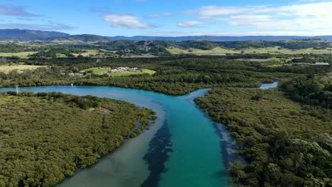 aerial establishing dolly of minnamurra river winding through wetlands and coastal vegetation in nsw, australia