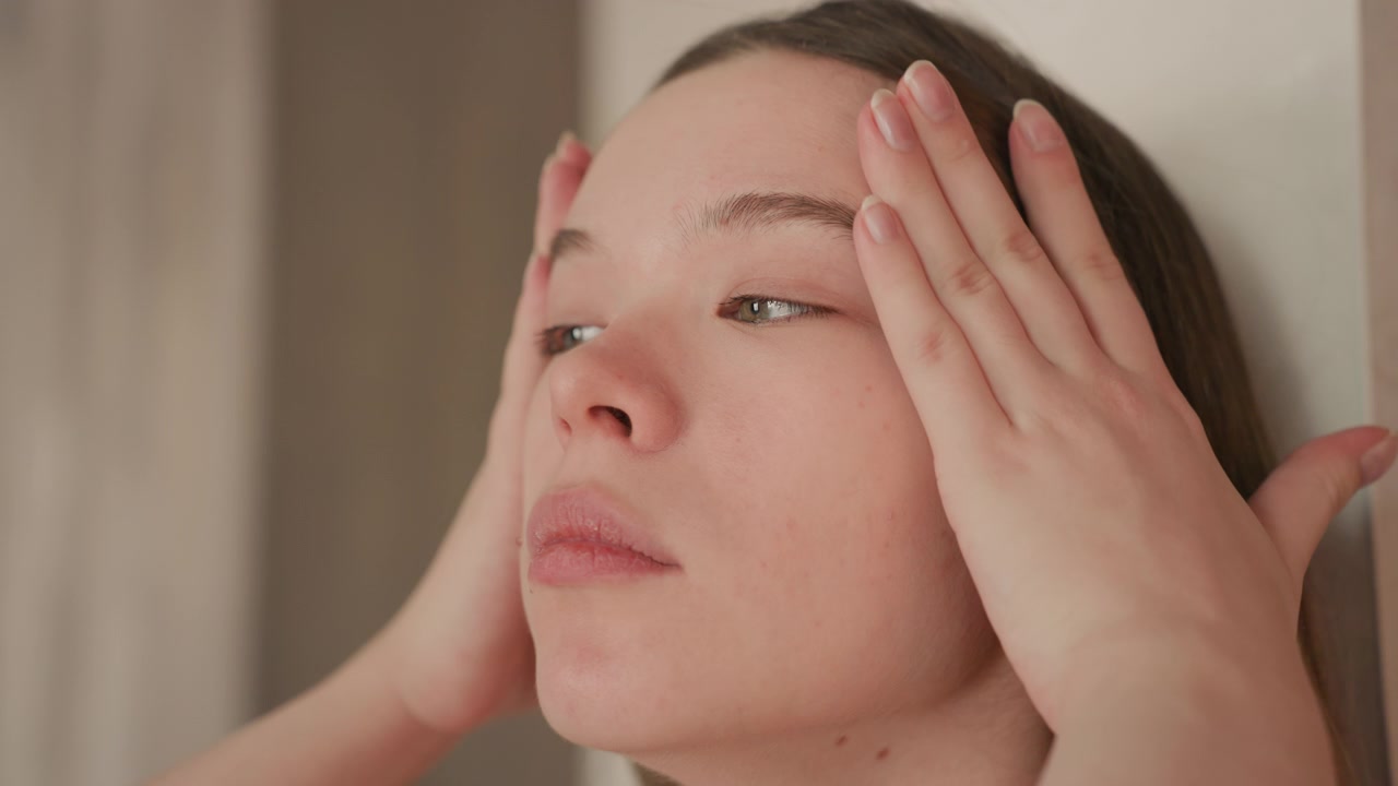 瞑想しながら顔に触れる若い女性のクローズアップ