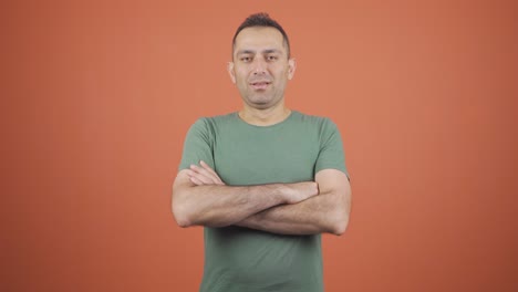 businessman with arms folded and laughing at camera.