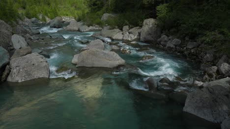 water flowing through the rocks and boulders in valmalenco, italy