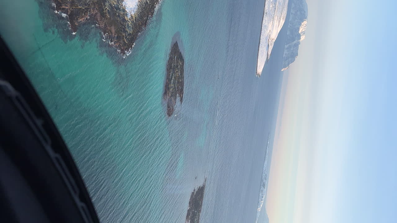 вертикальный снимок из вертолета внутри арктического круга с заснеженным островом во время полета