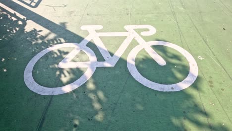 sombras que se mueven sobre un símbolo de carril para bicicletas