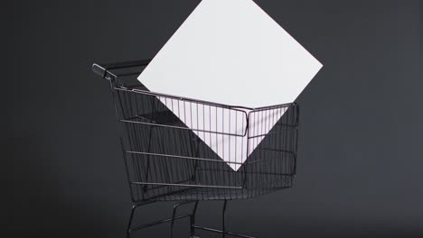 video of shopping trolley and canvas with copy space over grey background