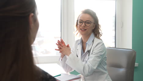 Doctora-Sonriente-Atendiendo-A-Un-Paciente-En-Su-Consulta