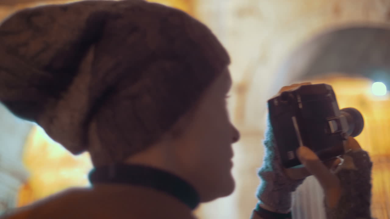 turista usando una cámara retro para filmar el coliseo nocturno