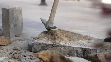 construction worker breaking up concrete with a hammer