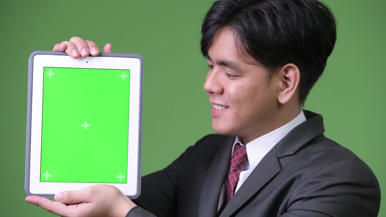 디지털 태블릿을 사용하는 젊은 잘생긴 아시아 사업가