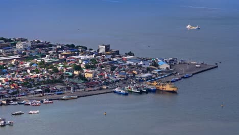 aerial drone shot of surigao city harbour- philippines, with calm sea and a few boats docked