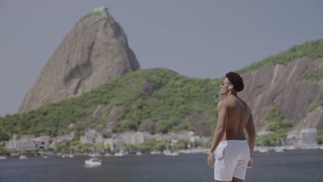 Man with outstretched arms overlooking Sugarloaf Mountain in Rio de Janeiro