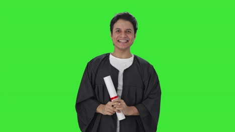 feliz estudiante universitario indio arrojando gorra en la pantalla verde de la graduación