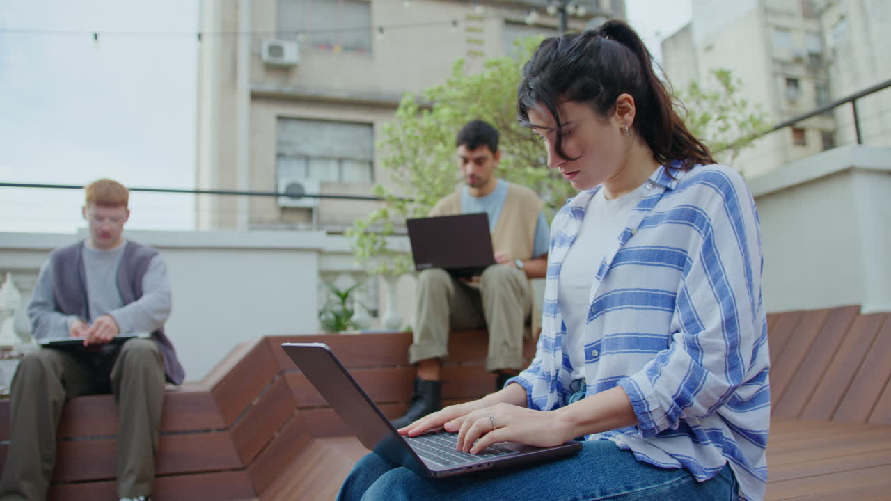 Young Woman Using Laptop Outdoors in the City