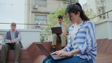 young woman using laptop outdoors in the city