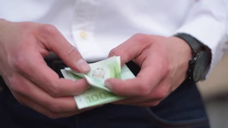 Junger-Geschäftsmann-Mit-Uhr-Am-Handgelenk,-Der-Euro-Banknoten-Zählt