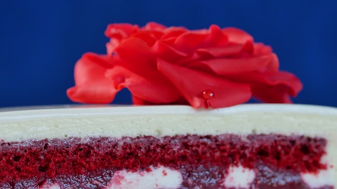 primo piano di una torta di velluto rosso con decorazione a rosa rossa