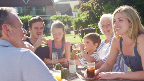 multi generation family enjoying outdoor summer drink at pub