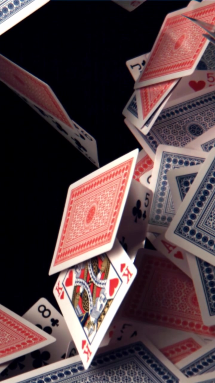 Carte da gioco che cadono e fluttuano al rallentatore su sfondo nero