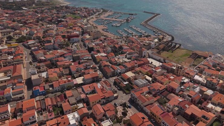 Veduta aerea di Portoscuso nel Sulcis-Iglesiente, Sardegna, Italia, che mostra la città costiera e il paesaggio mediterraneo circostante.