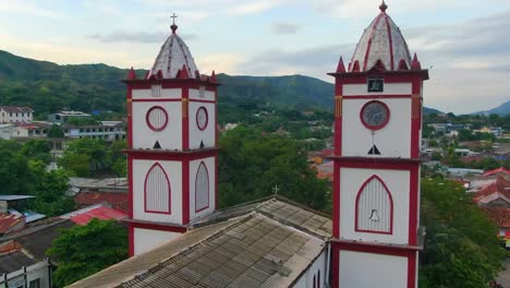 Aerial-dolly-towards-white-religious-building-as-doves-fly-off-turret-towers