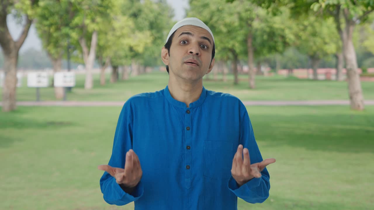 Hämmentynyt muslimimies kysymässä "Mitä?" puistossa.