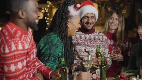 tracking shot pulling away from group of friends celebrating christmas at a bar