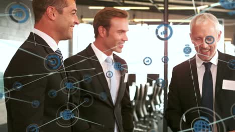 animation of network of business icons over smiling diverse business people shaking hands
