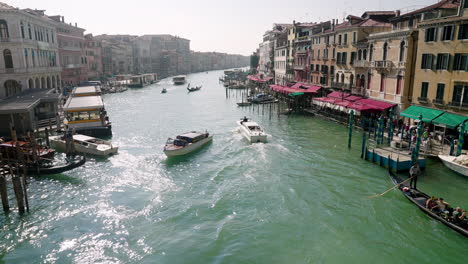 boats and gondolas sailing on grand canal, view from rialto bridge in venice, italy - wide