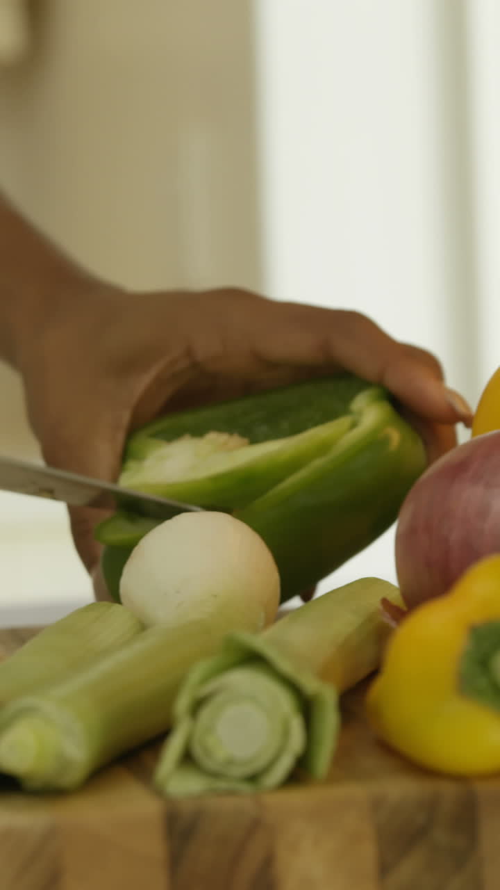 sección media de una mujer cortando verduras en la cocina
