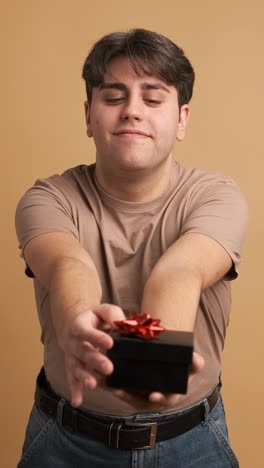 happy man giving present and looking at camera