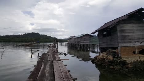 caminando sobre una plataforma de madera con un niño pescando en misool, raja ampat, indonesia, asia