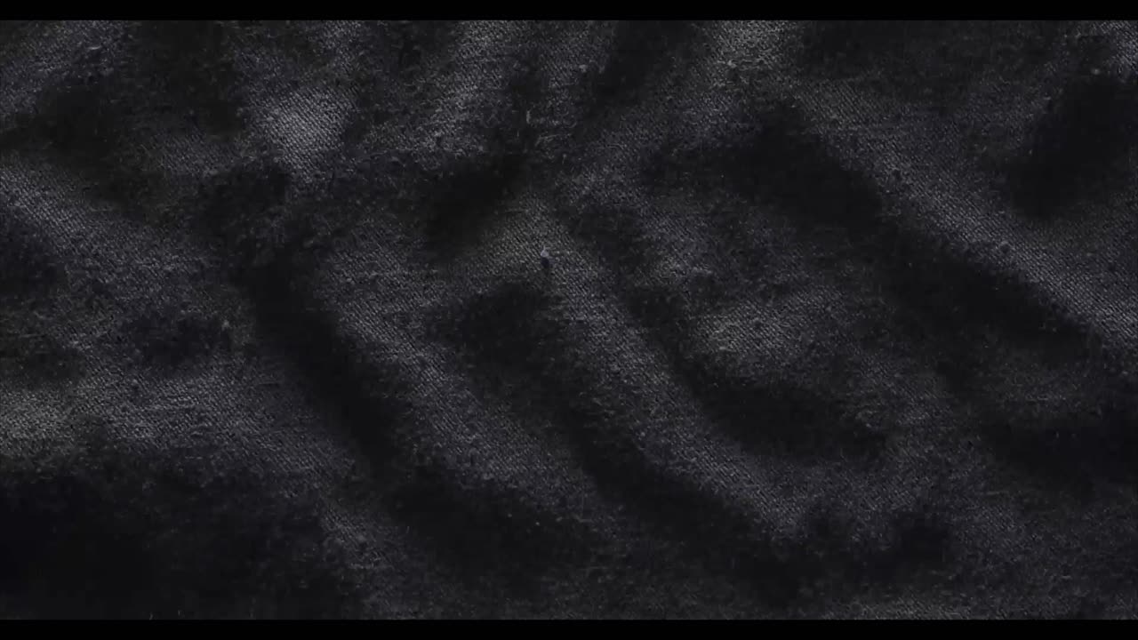 Dynamisk tekstur af mørkt vævet stof, der bølger