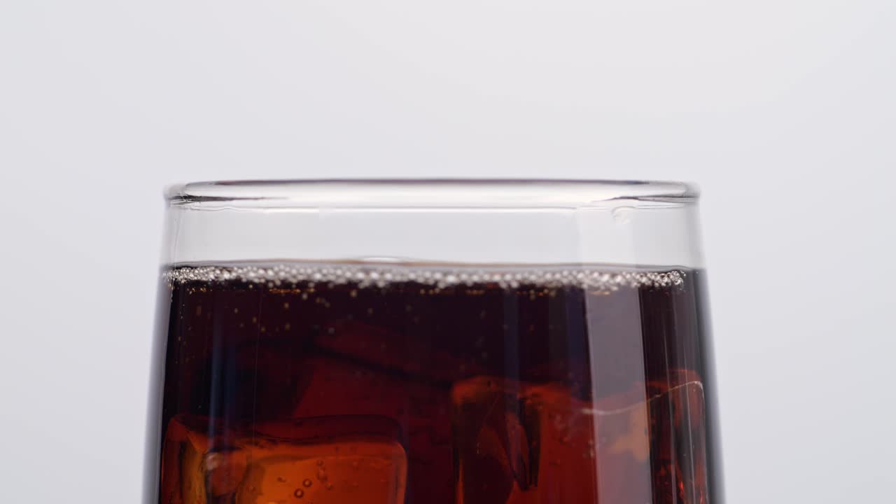 바탕에 신선한 콜라 한 잔에 떨어지는 얼음 큐브의 가까운