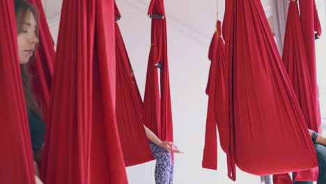 barefoot women legs sitting in oriental fly yoga hammocks