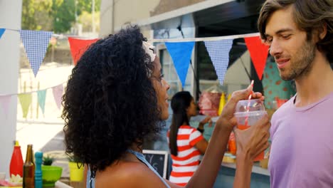 una pareja romántica compartiendo jugo.