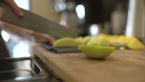 close up of female hands slicing green apple