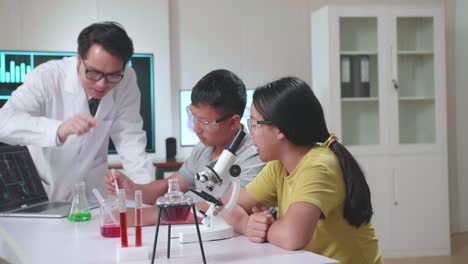 young asian boy and girl learning science experiment in laboratory at classroom. study with scientific equipment and a microscope