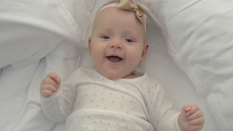 top view of an adorable baby girl with a golden bow