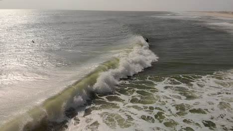 epic drone tracking shot of surfer riding a wave