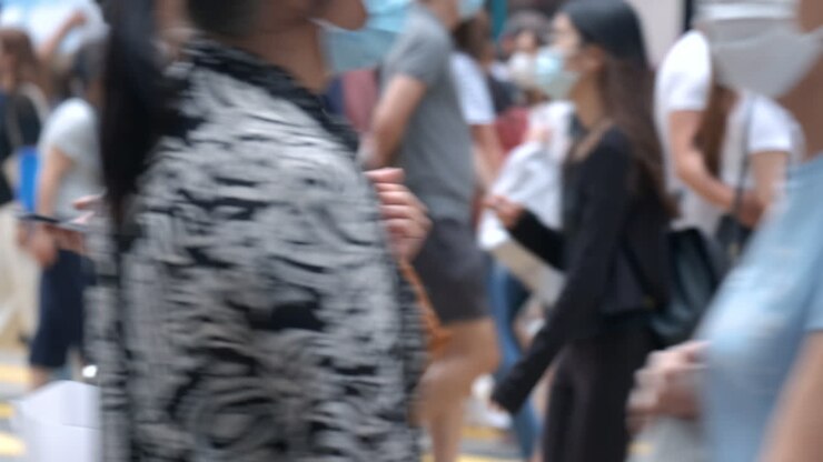 Rallentatore di persone irriconoscibili che indossano mascherine mediche a Hong Kong