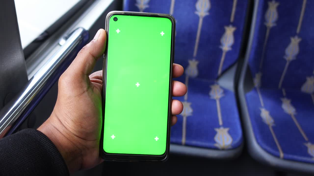 persona con un teléfono inteligente de pantalla verde en un autobús