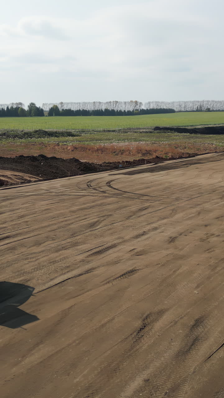 Vast Earthwork Site with Construction Equipment and Distant Rural Landscape