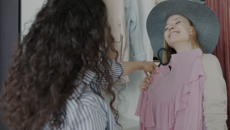 two friends trying on clothes in a fitting room