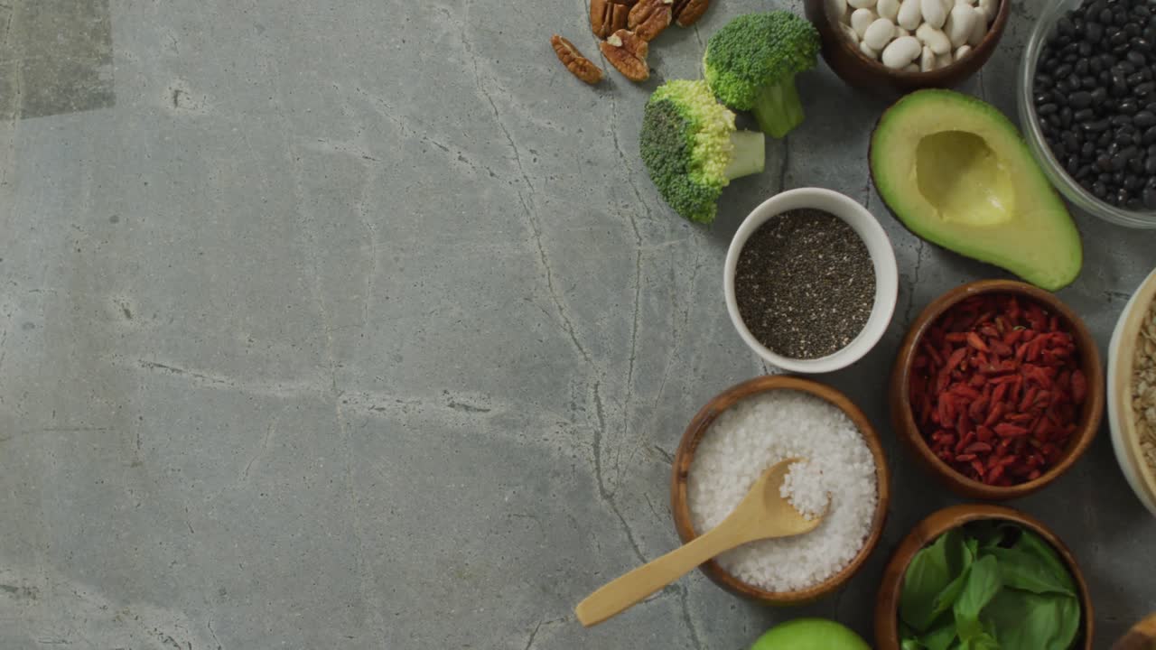 Video of fresh avocado, broccoli and bowls of plant based ingredients with copy space