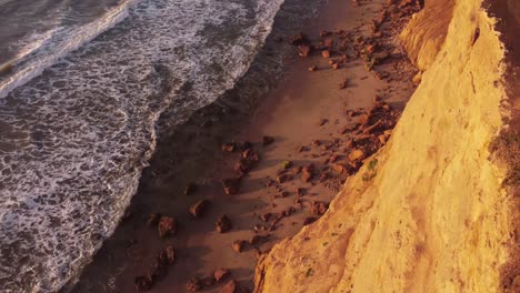 Top-down-Luftaufnahme-Des-Strandes-über-Der-Klippe-Während-Des-Sonnenuntergangs