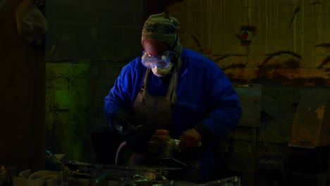 worker using hand grinder machine in foundry workshop 4k